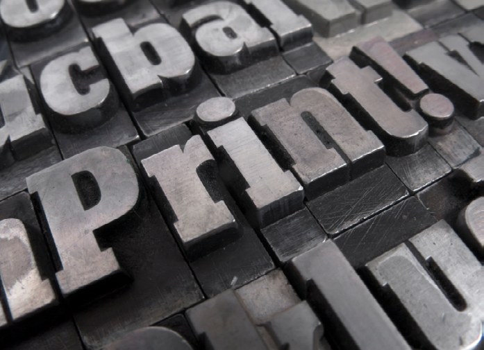 A close-up of metal letterpress type spelling 'print'