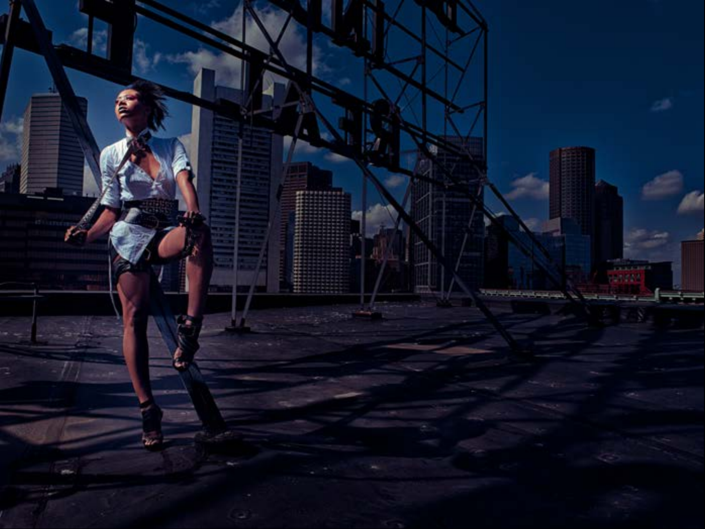 Fashion photograph by Frank Doorhof, a model on a rooftop against a city skyline
