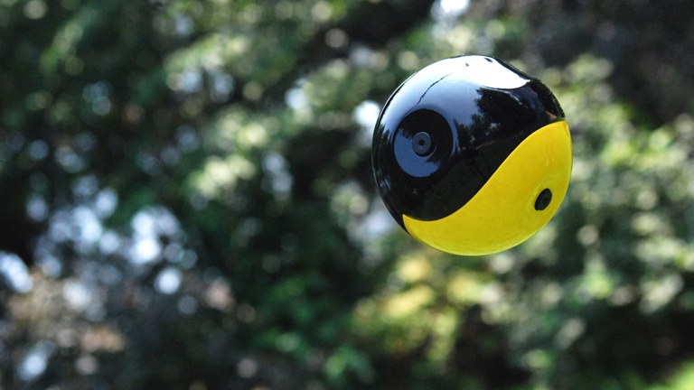 The Squito throwable camera ball in mid-air against a leafy background