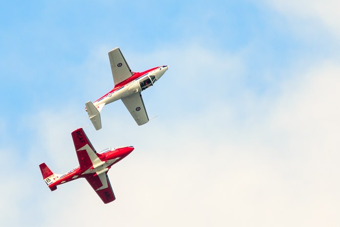 Two Snowbirds aerobatic jets in formation against a blue sky
