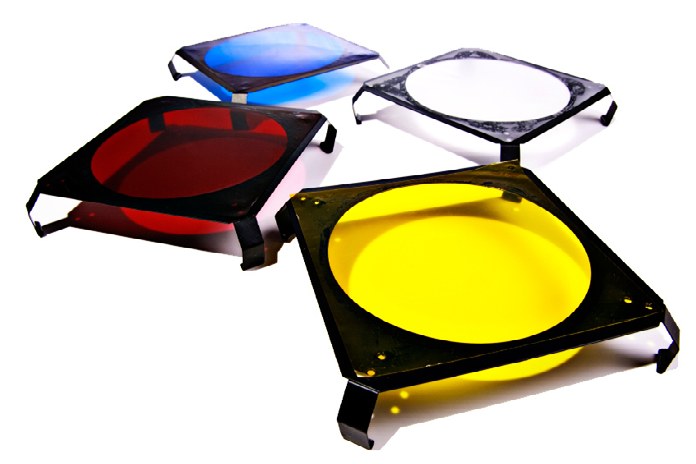 A set of coloured lighting gels in frames: blue, red, white, and yellow