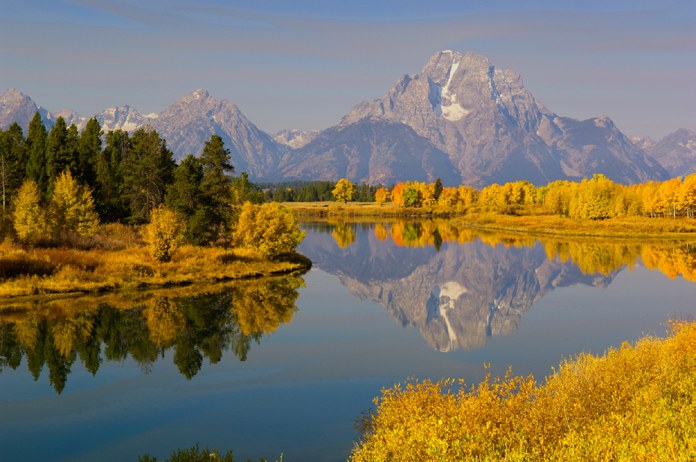 Autumn mountains reflected in a calm lake at an Oxbow Bend