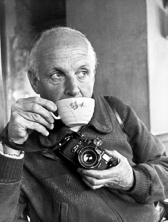 A portrait of photographer Henri Cartier-Bresson holding a Leica